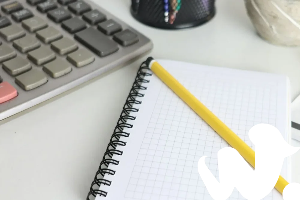 Calculadora y cuaderno sobre un escritorio para calcular el bono del Kit Digital